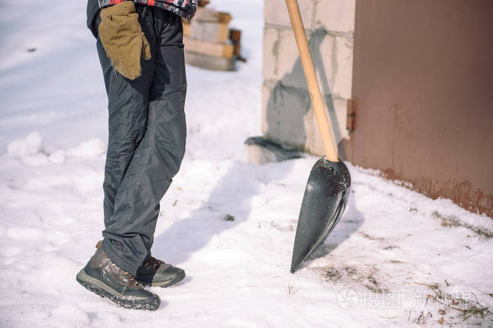 用铲子把雪擦干净那个人铲雪铲手里拿着雪铲冬天打扫这个地方