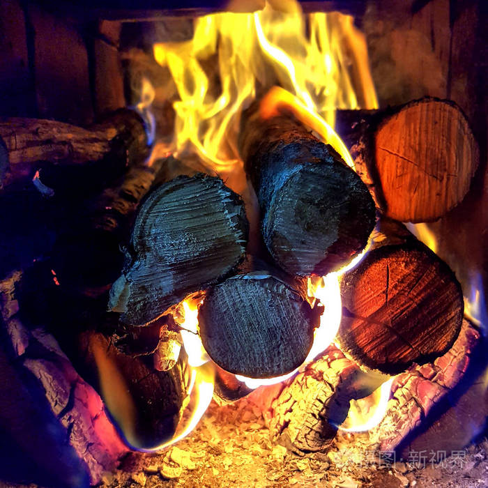 木炭和原木在明火筒壁炉里燃烧