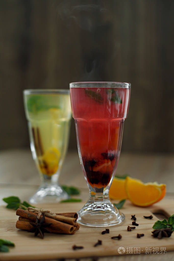 两个装有彩色热饮的玻璃杯里面有蒸汽冬季热饮