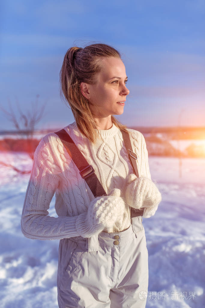 穿着白色工作服和毛衣的美女,冬天空气清新,背景上飘着雪花