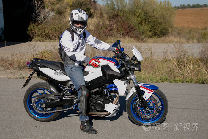 戴头盔骑摩托车的摩托车手骑摩托车旅行摩托车手站在路上
