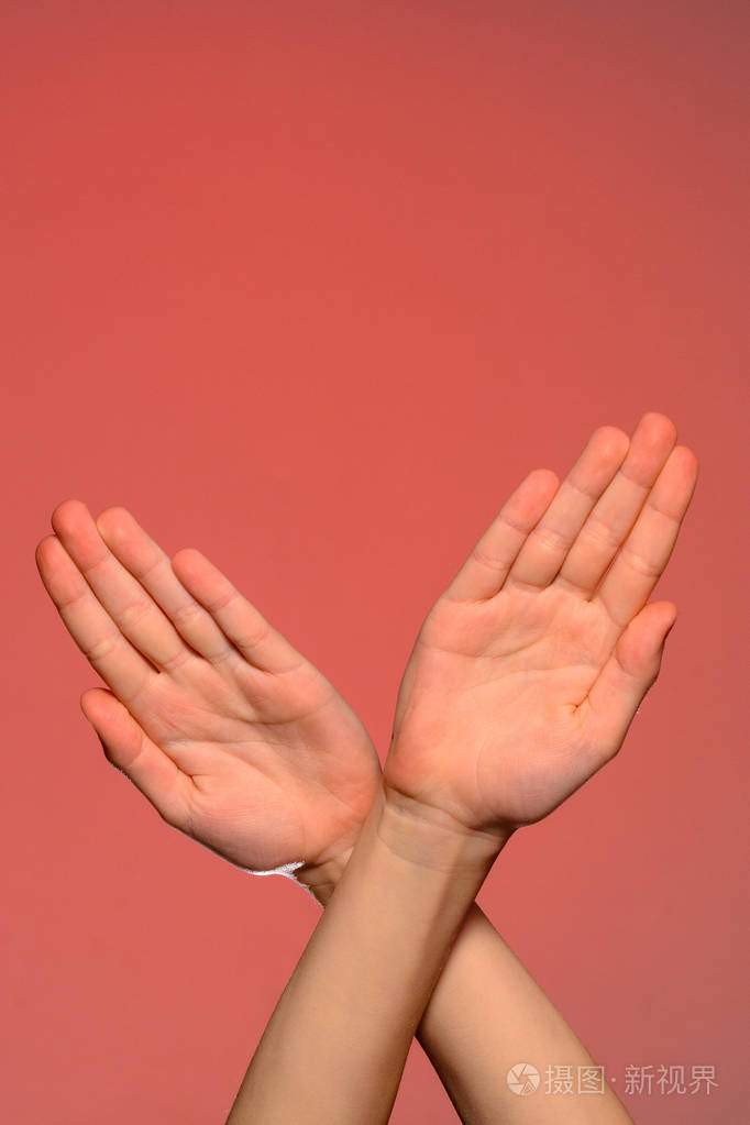 双手交叉交叉交叉象征着鸟的翅膀或xx的符号孤立在红色背景上