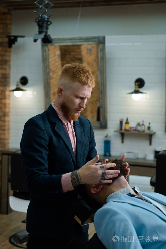 高级男子在理发店拜访发型师.理发剪和剃须刀.