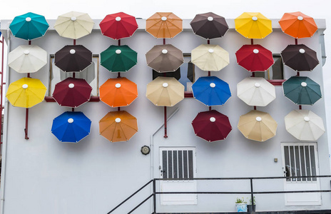 建筑物墙壁上装饰着鲜艳的雨伞图片