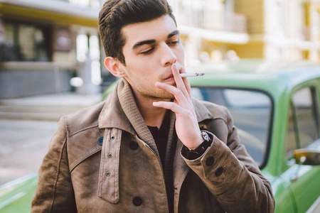 抽烟帅气姿势一个年轻帅气性感的黑发男人模特儿的肖像,深色皮肤的