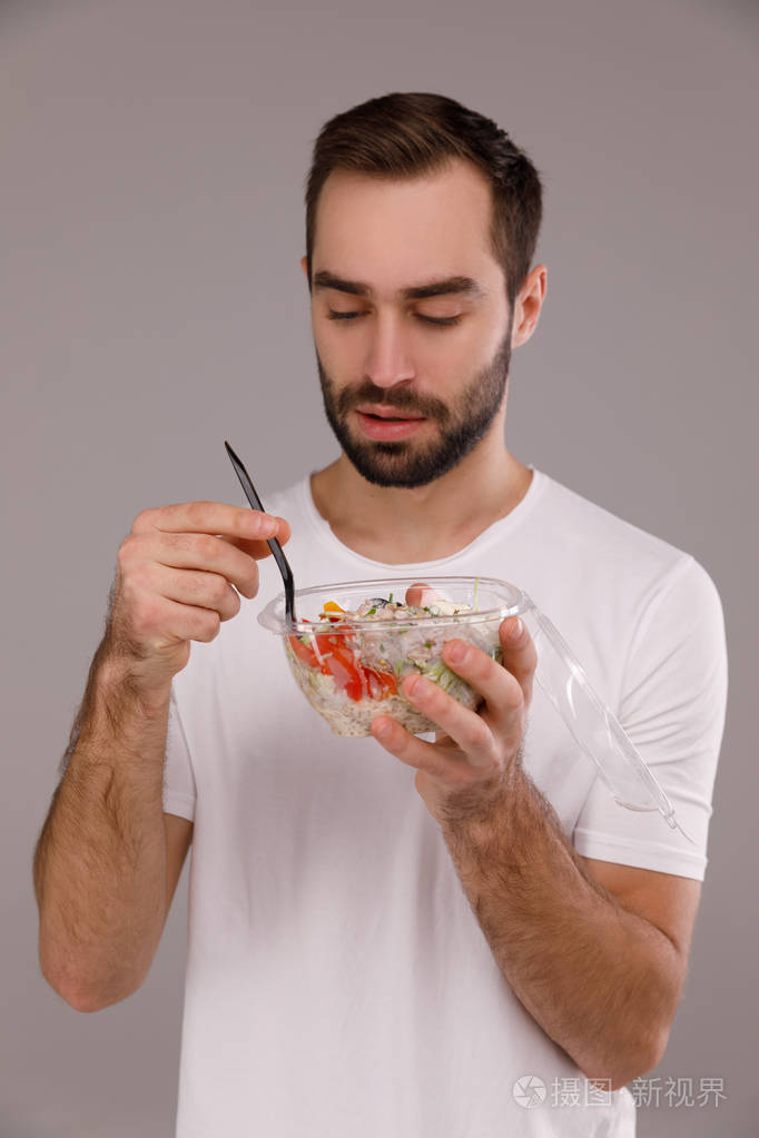 一个男人用筷子吃素食的戳碗一个男人手里拿着戳碗
