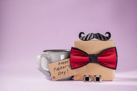 父亲节手工一个礼品盒,用手工纸包装,并在背景上系上蝴蝶结.