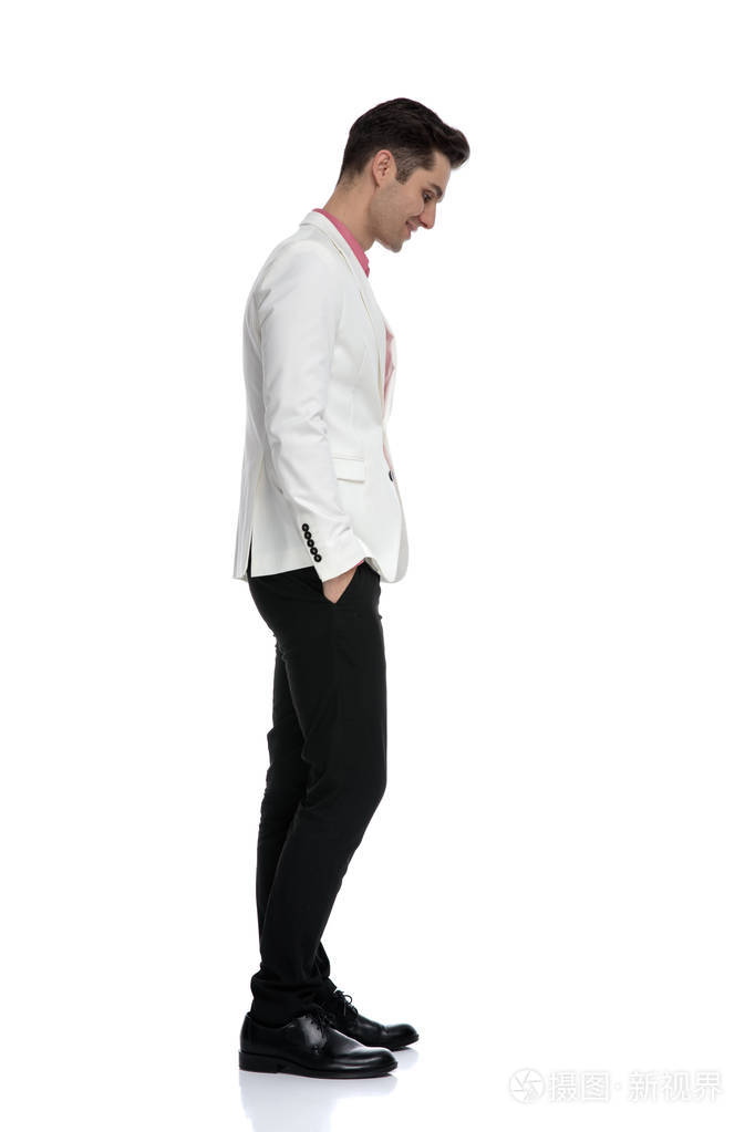 面带微笑的男人双手插在口袋里,低头看着照片-正版商用图片2h4al4-摄