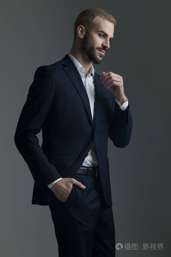 穿西装的金发男子把手放在口袋里