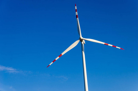 自然风车在蓝天下的绿色田野里的风车.自然友好照片