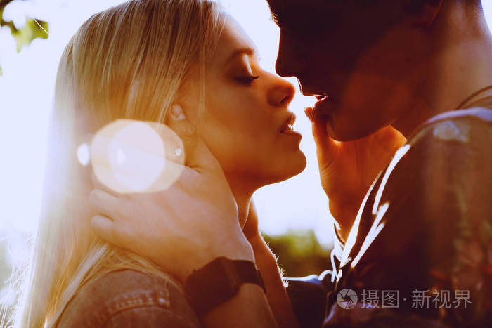 可爱的年轻白人夫妇拥抱和亲吻太阳