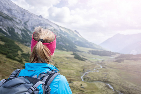 这场运动背着背包的金发女登山者正在享受这场比赛照片