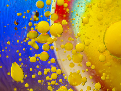 五彩缤纷的宏飞溅的黄色颜料滴,抽象的背景.特写镜头.背景模糊.