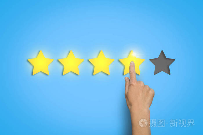女性的手在蓝色的背景上会有五分之四的星星评价某物的概念