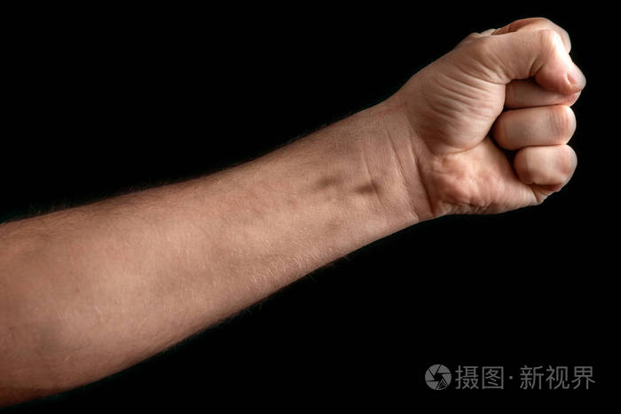 黑色背景下孤立的拳头一个强壮的男人在黑色背景下举起拳头力量抗议