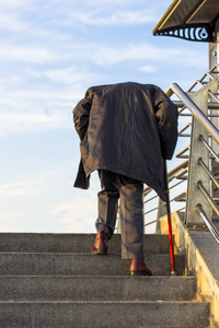 老人乏力拄着拐杖爬楼梯的老人照片