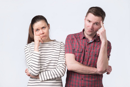 疑惑男迷人的年轻夫妇肩并肩站在一起,疑惑不解照片