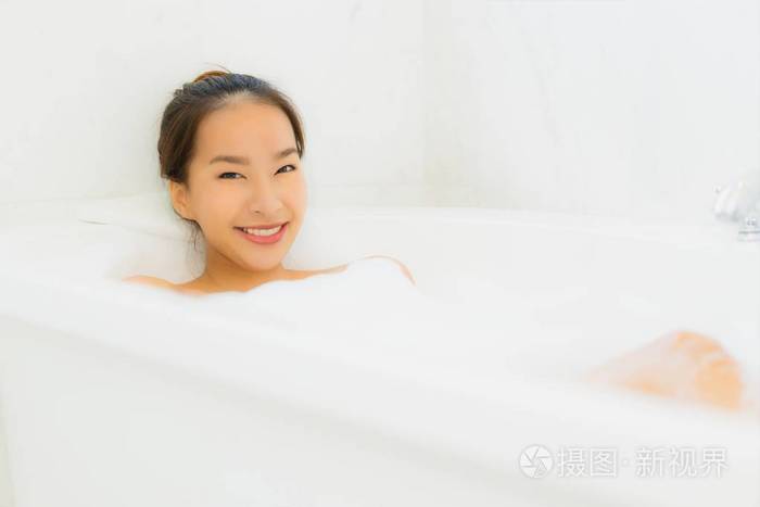 美丽的亚洲年轻女子在浴室里洗澡