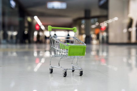 在商场买东西的概念.购物车背景模糊玩具超市.在百货公司购物和消费.