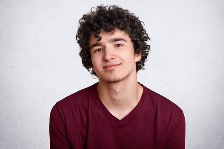 站在留着看一个留着小胡子,穿着栗色衬衫,留着卷发的欧洲少年的特写