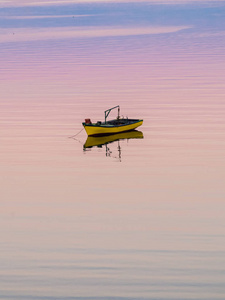 钓鱼船日出莱斯沃斯一艘小船在宁静的水面上漂浮,在令人惊叹的日落下