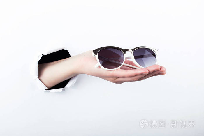 女的手从造纸工的洞里伸出来拿着太阳镜看东西隔离白色背景