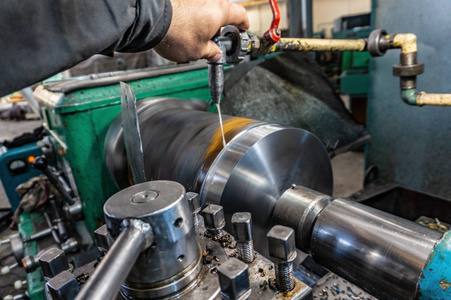 车工在车床上管理机械切削的金属加工过程.照片