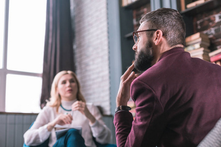 贴地满脸胡须的男人体贴地回答心理学家的问题照片
