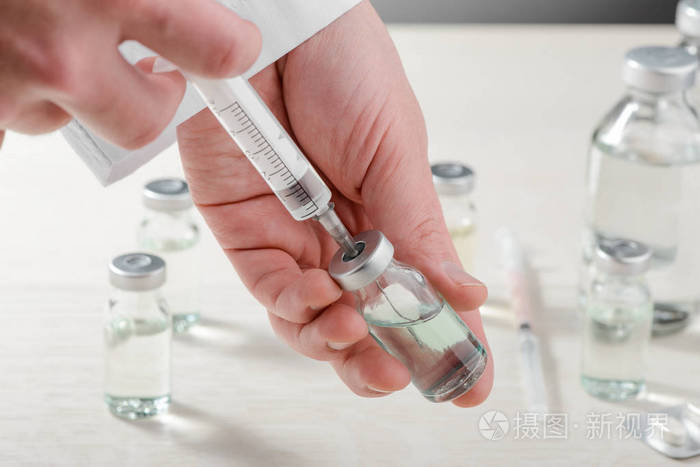 医生将疫苗吸入注射器
