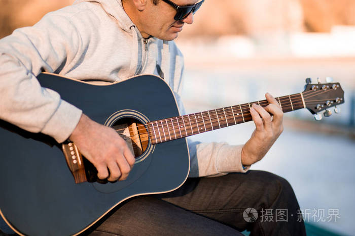 年轻人坐在台阶上弹吉他唱歌音乐理念