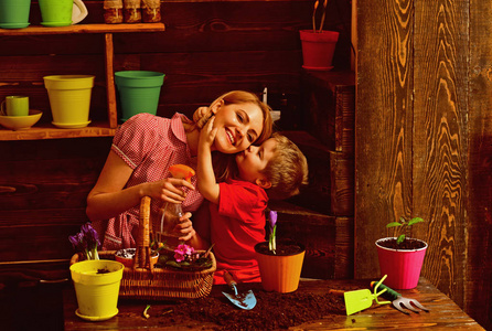 小孩子用爱亲吻种花的母亲.在爱中成长.爱护自然照片