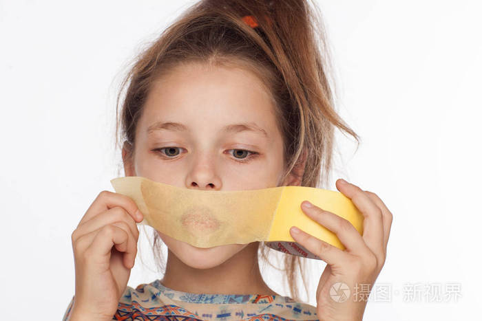 一个情绪激动的8岁女孩的画像她的头发向上竖起穿着一件上衣嘴上贴着