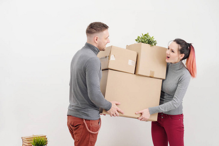 拿包的东西一个年轻的女人和一个男人拿着装满东西的重纸板箱.