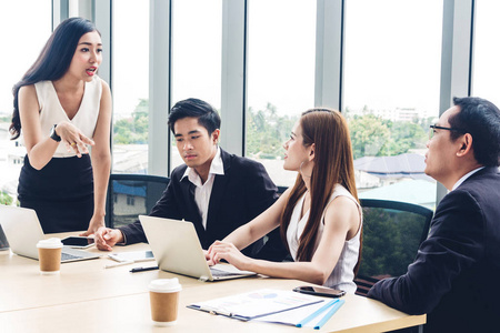 与笔记本电脑公司讨论和合作的休闲商务小组照片