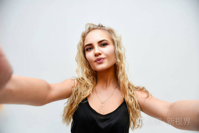 白牙金发女模特看着相机微笑的照片孤立在白色背景上