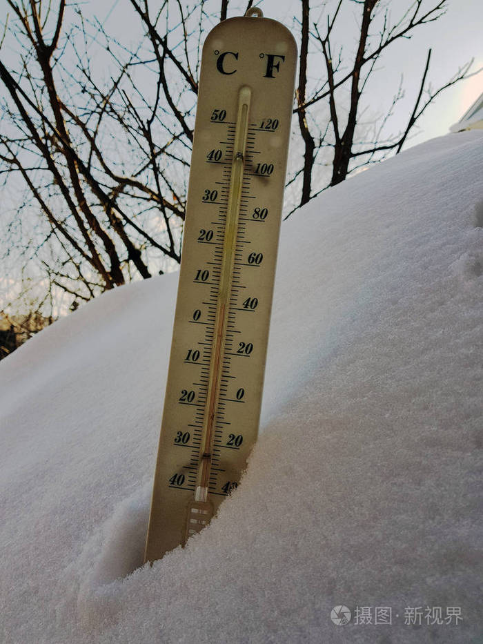 在雪中有摄氏度和华氏度的街道温度计