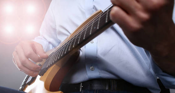 男性手臂弹奏经典形状电吉他图片