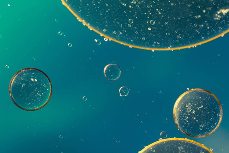 黄色背景下抽象风格的油包水.橙色液体飞溅.金黄色泡泡油抽象背景.