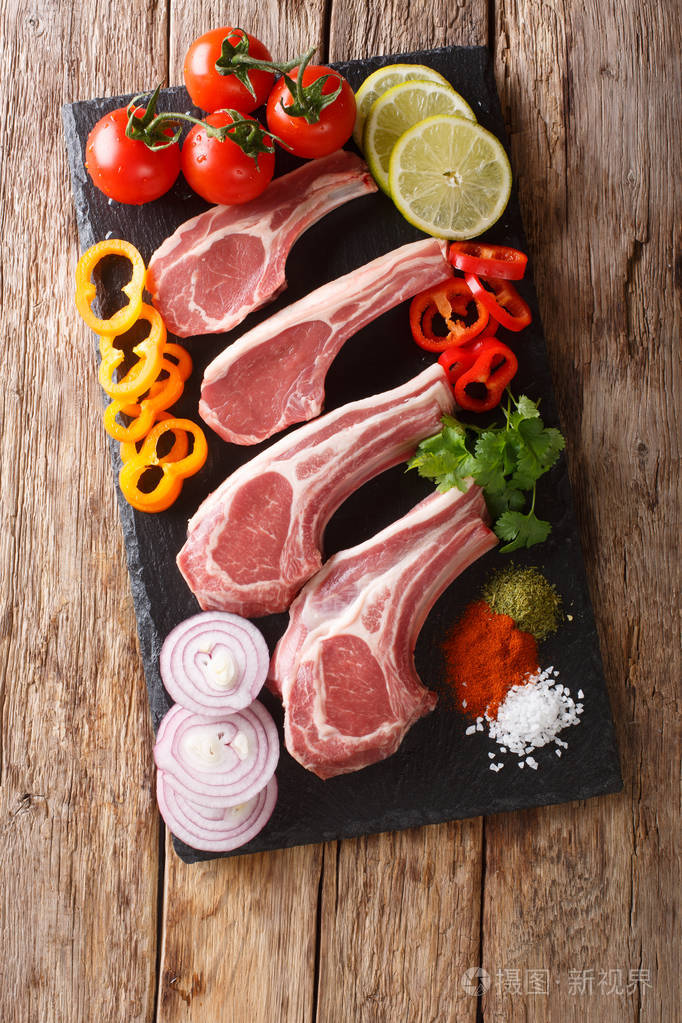raw lamb cutlets with fresh vegetables and spices close-up on a