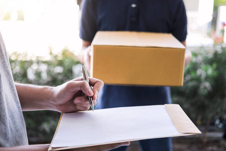 收件地址邮递员把包裹箱交给收件人,年轻人签字照片