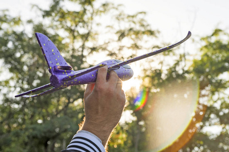 手玩模型在蓝天下,男人手举玩具飞机的特写照片.