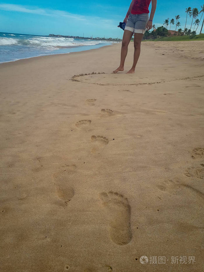 走在沙滩上的女人在沙滩上留下脚印巴西女性脚的特写细节