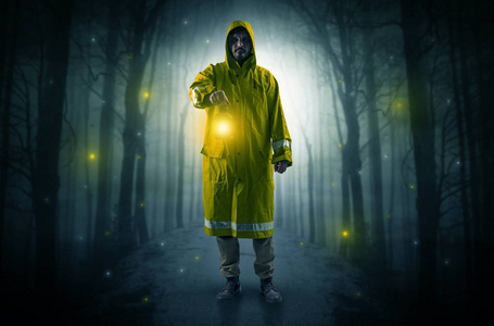 神秘人从森林里的小路上走出来,带着发光的灯笼概念照片