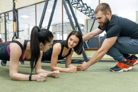 私人团队私人健身教练指导和帮助客户女性在健身房锻炼.