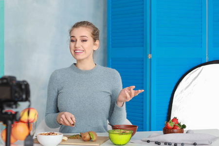 年轻女美食博主在室内录制视频照片