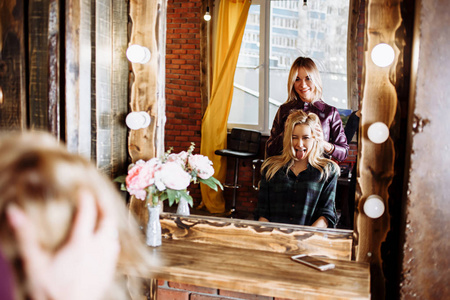 发廊里坐在镜子前的美女.理发师照片