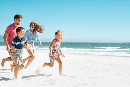 快乐的一家人在沙滩上奔跑图片