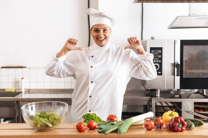 身着白色制服的微笑女厨师正在做饭