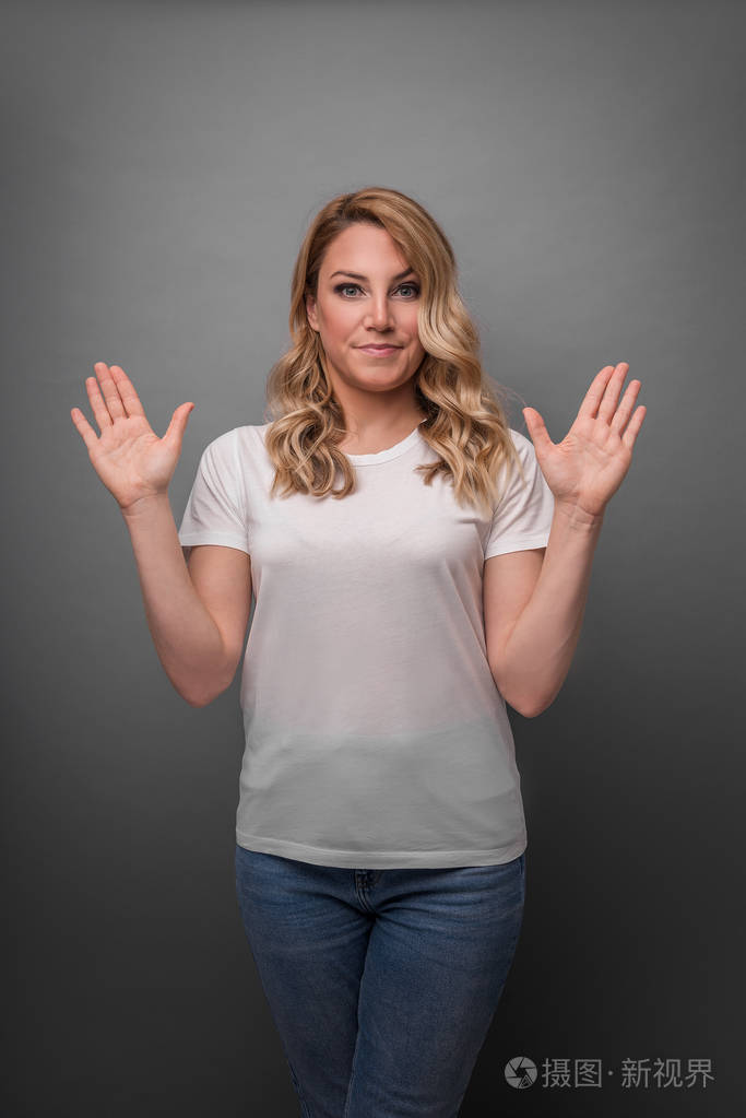年轻女子举起双手表示惊讶或否认