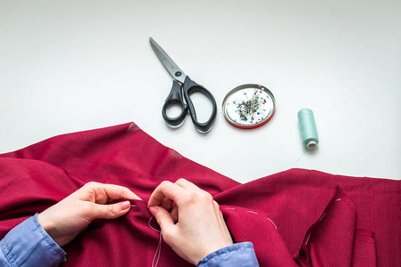 手工艺人女裁缝用手缝衣服.女人的手.特写.手工艺概念.照片